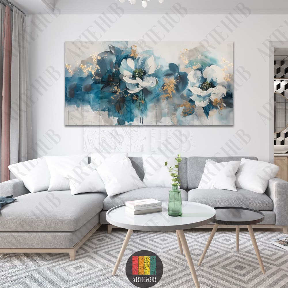 A large horizontal canvas wall art featuring two abstract white flowers with teal and gold leaf detailing above a light grey sofa.