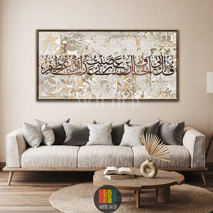 A large horizontal framed canvas wall art with elegant Arabic calligraphy over a weathered tile pattern, displayed above a modern beige sofa.