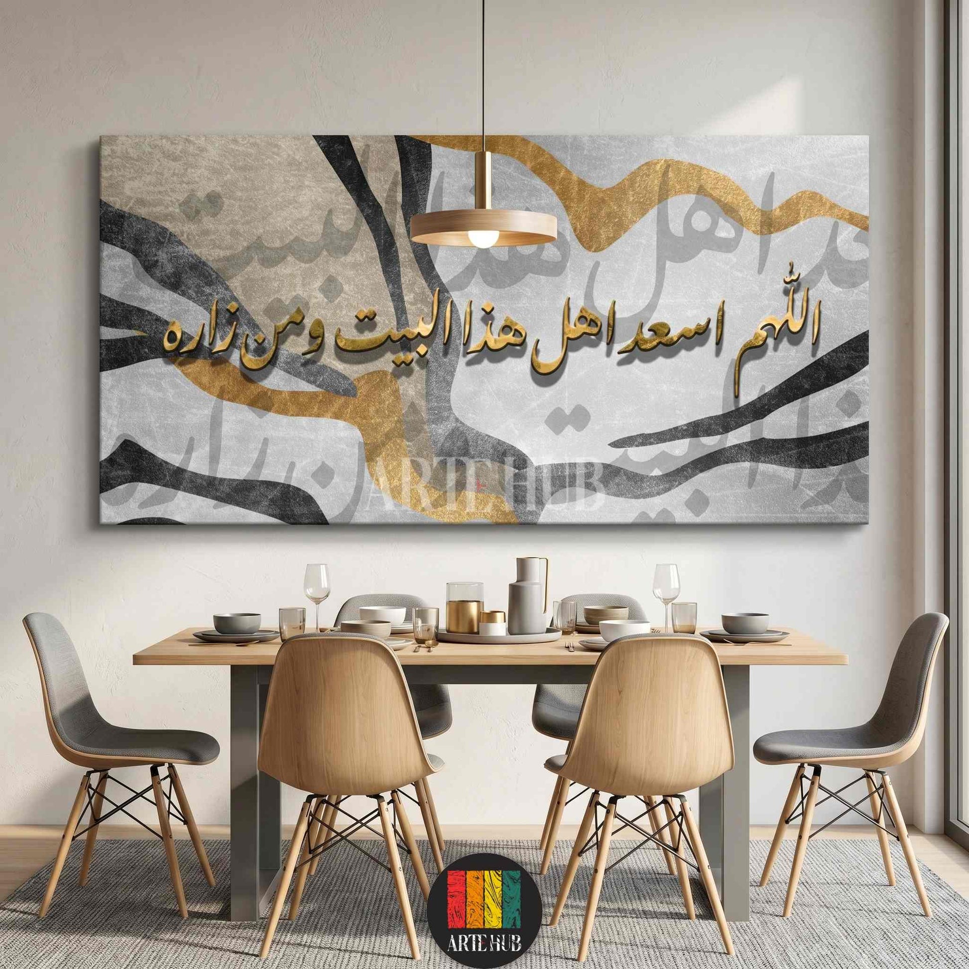 A large horizontal canvas wall art with golden Arabic calligraphy over abstract grey and gold brushstrokes, styled above a dining table in a modern home.