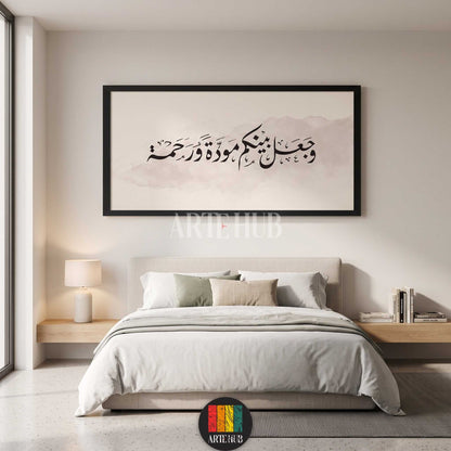 A large horizontal framed canvas wall art featuring black Arabic calligraphy on a soft neutral watercolor background, styled in a minimalist bedroom in Egypt.