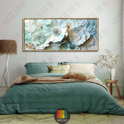 A wide horizontal framed canvas wall art featuring 3D-style light blue and white flowers with subtle gold details hanging above a bed.