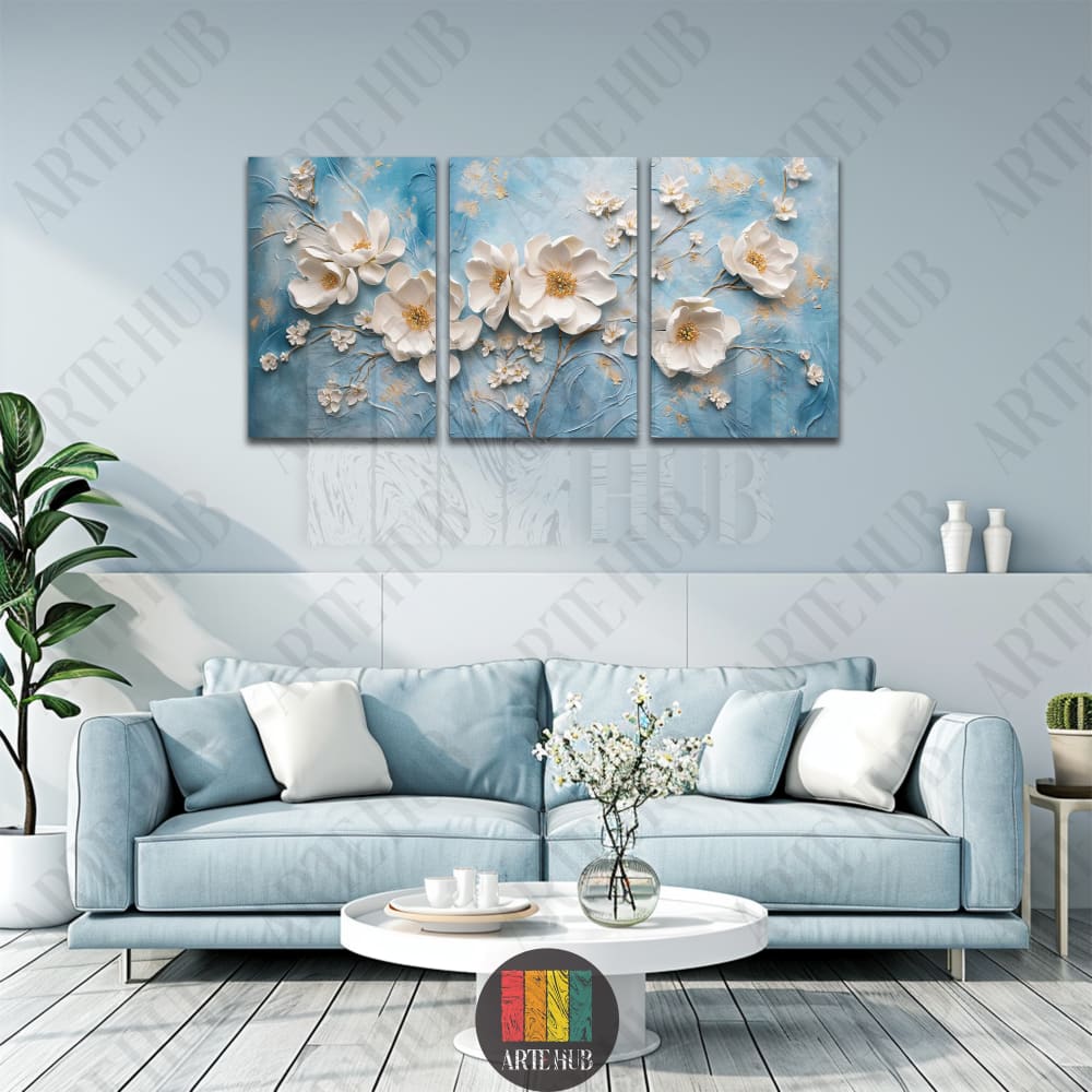 Luxury 3-piece canvas wall art with 3D white flowers and gold accents on a blue textured background in a modern Egyptian home.
