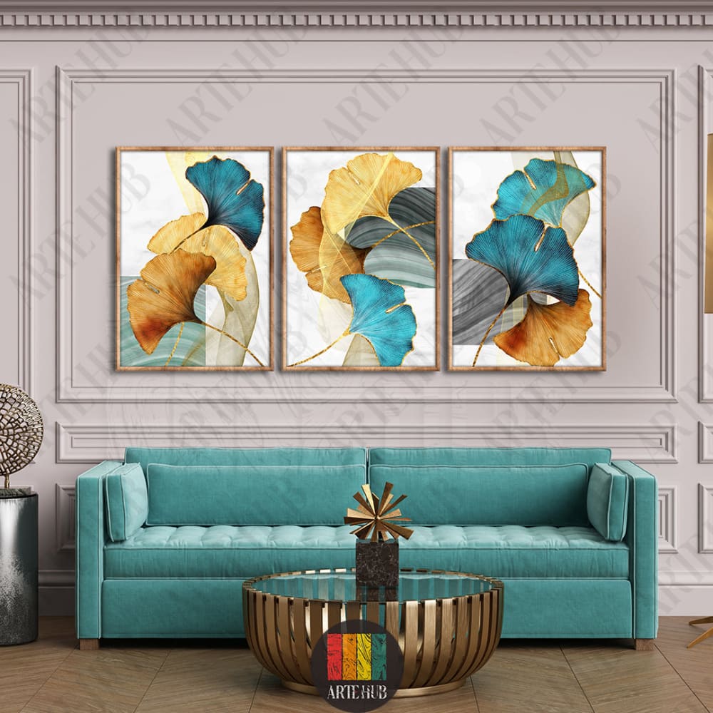 Triptych canvas wall art featuring teal and gold ginkgo leaves in a luxury modern living room setting in Egypt.