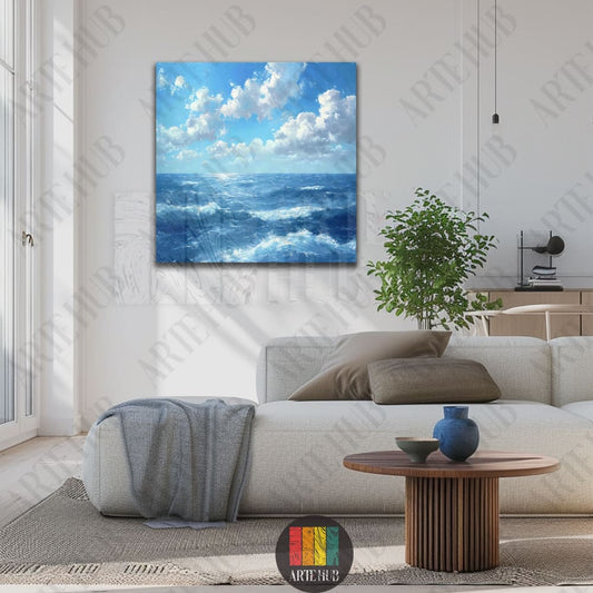 A serene square canvas wall art featuring a dreamy blue ocean seascape with white clouds and crashing waves in a modern living room setting.