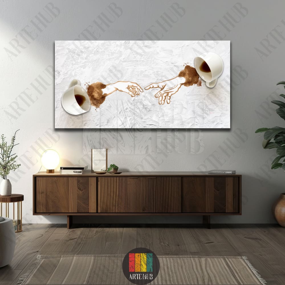 Modern canvas wall art featuring coffee spills forming the iconic Creation of Adam hands between two white cups on a white textured background.