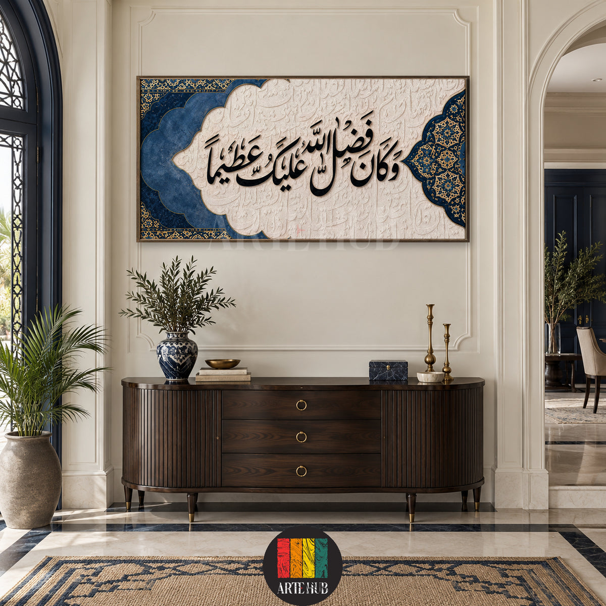وكان فضل الله عليك عظيما — navy and ivory Arabic calligraphy with ornamental corners, canvas wall art in a entrance console interior, Artehub Egypt.