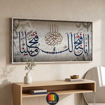 A horizontal luxury canvas wall art piece featuring modern Arabic calligraphy in blue and red tones over a textured grey background in a minimalist room.