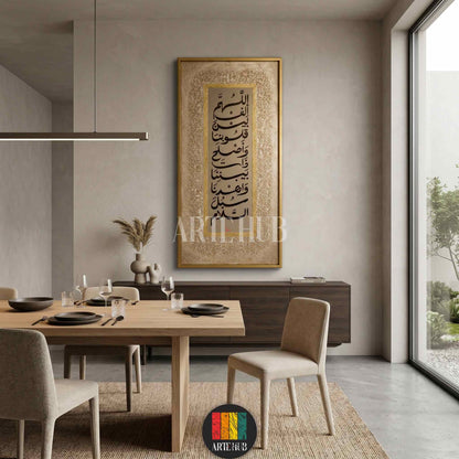A vertical gold-framed canvas wall art featuring elegant black Arabic calligraphy on a textured beige background, displayed in a modern minimalist dining room in Egypt.