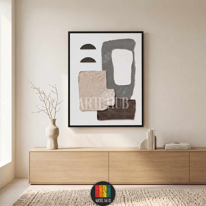 A minimalist abstract canvas wall art piece with textured earth tones and geometric shapes in a black frame, styled in a modern living room in Egypt.