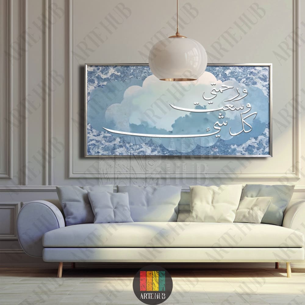 Framed canvas wall art featuring elegant white Arabic calligraphy of the Quranic verse My mercy encompasses all things over a blue cloud background.