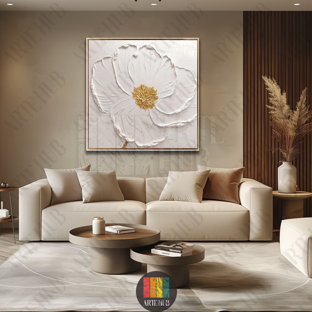 A textured 3D-style white flower canvas wall art with golden details and a blue center, displayed above a modern beige sofa in a luxury living room.