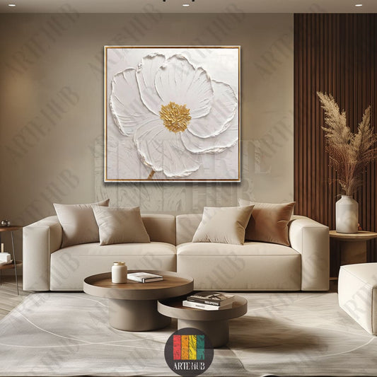 A textured 3D-style white flower canvas wall art with golden details and a blue center, displayed above a modern beige sofa in a luxury living room.