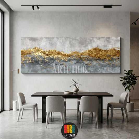 A luxurious panoramic abstract canvas wall art featuring metallic gold leaf textures and grey brushstrokes, styled in a modern minimalist dining room.