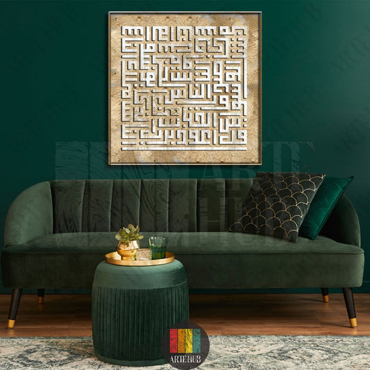 A square canvas featuring intricate white Kufic Arabic calligraphy on a textured gold background, mounted on a dark green wall in a modern living room.