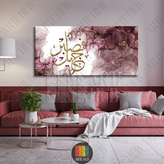 Modern Arabic calligraphy canvas wall art with Sabrun Jameel in gold on a maroon abstract ink background, luxury home decor in an Egyptian living room.